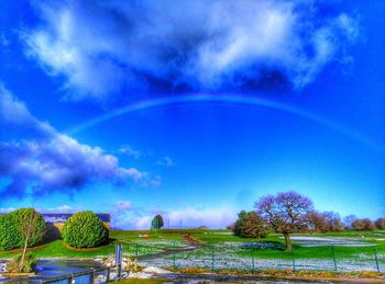 Scenic view of field against rainbow in sky