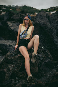 Portrait of young woman sitting on rock