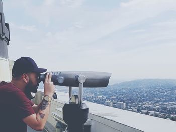 Man photographing cityscape against sky