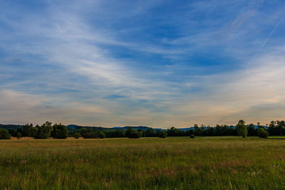 Scenic view of field against cloudy sky