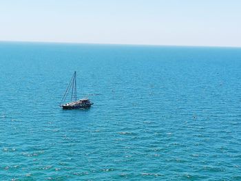 Sailboat sailing on sea against clear sky