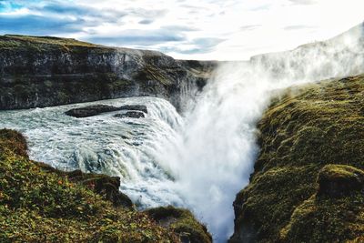 Scenic view of waterfall against sky