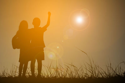 Silhouette hand against sky during sunset
