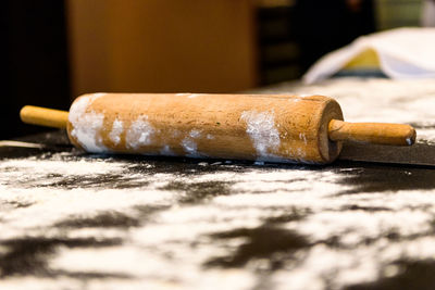 Close-up of rolling pin and flour on table