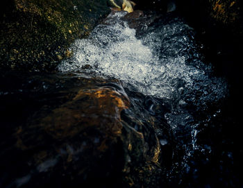 High angle view of water flowing through rocks