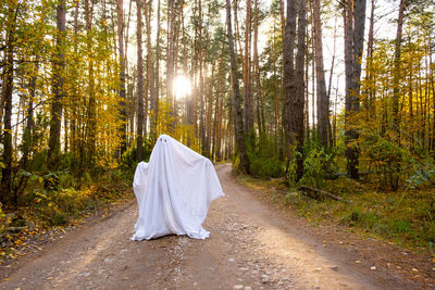 Rear view of woman walking in forest