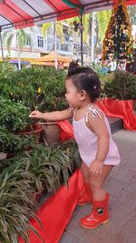 Cute girl smiling while sitting on plant