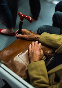 Low angle view of person with shoulder bag traveling in train