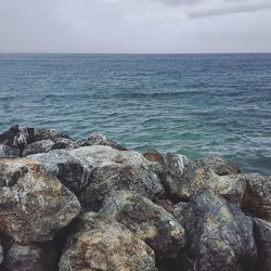 Scenic view of rocky beach against sky