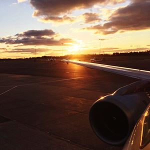 Close-up of airplane against sky during sunset