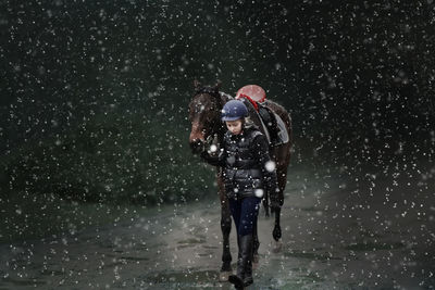 Full length of man with umbrella at night