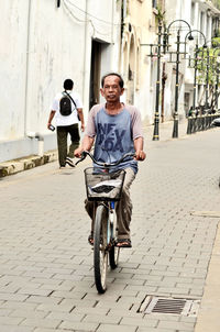 Rear view of man riding bicycle on street