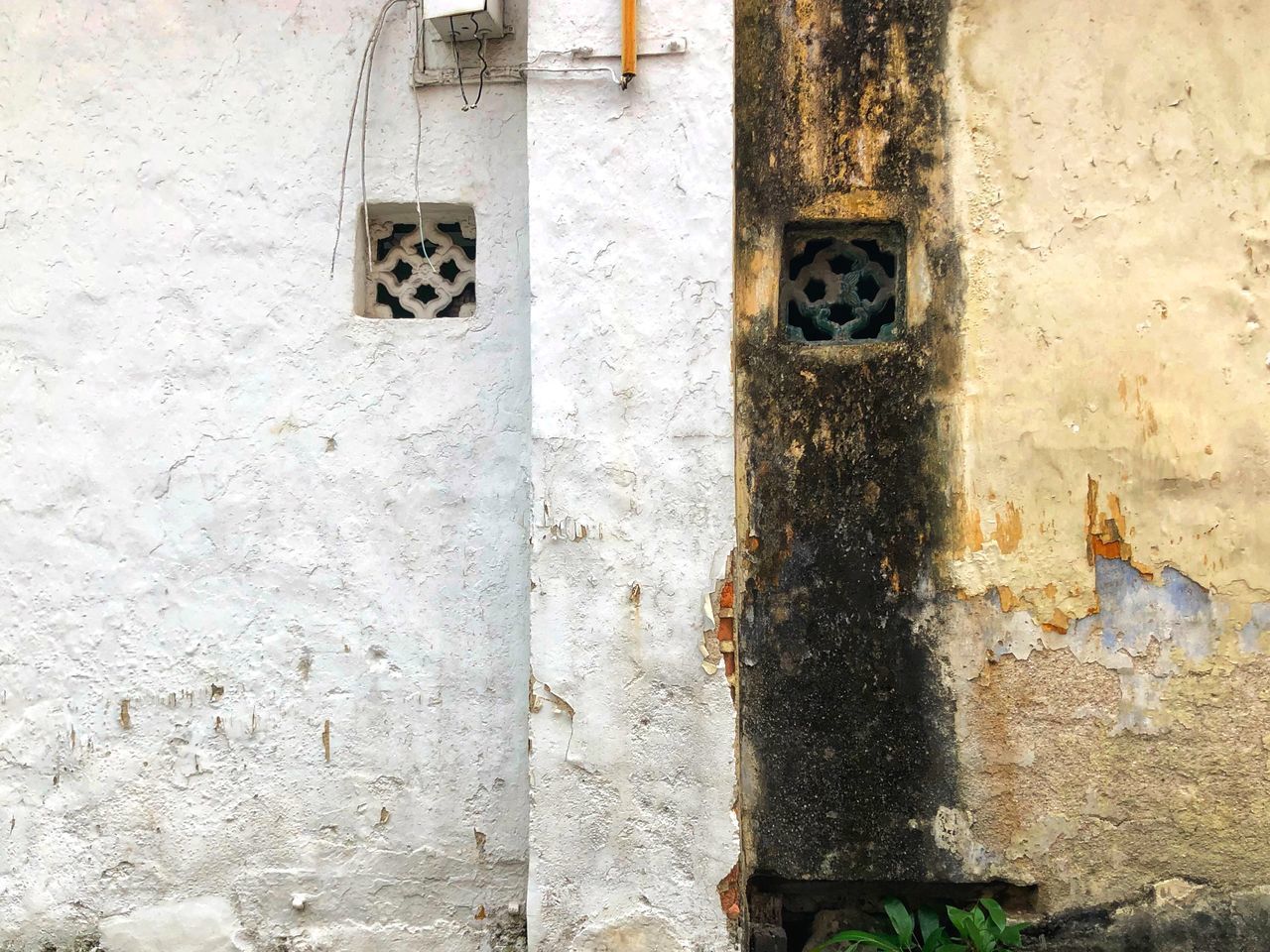 CLOSE-UP OF WEATHERED WALL WITH HOLE