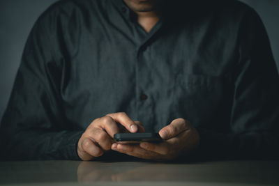 Midsection of man using mobile phone