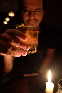 Man showing drink while sitting at table in restaurant