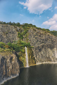 Scenic view of waterfall against sky