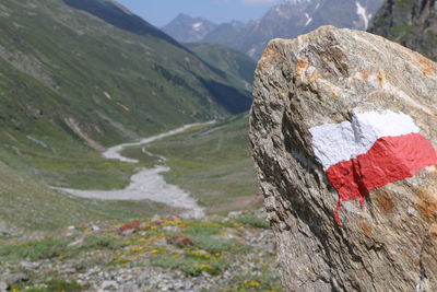 Close-up of rocks against mountains during sunny day