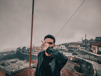 Portrait of young man standing against sky during winter