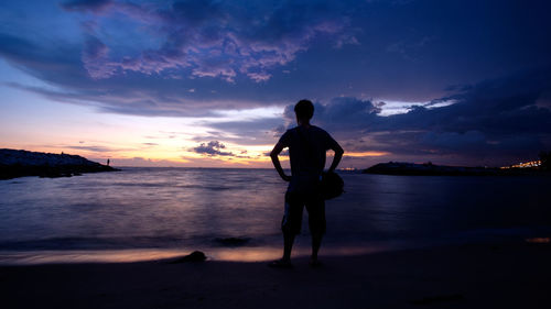 Scenic view of man at beach at sunset