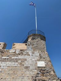 Low angle view of old building against clear blue sky