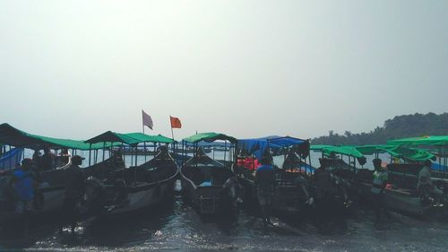 Crowd on water against clear sky