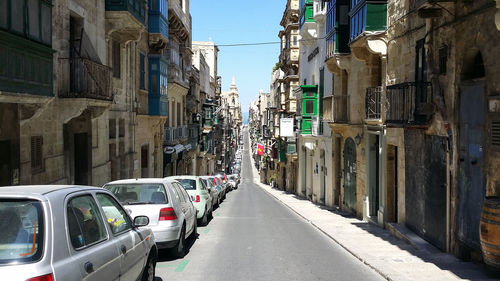 Cars parked on road amidst buildings