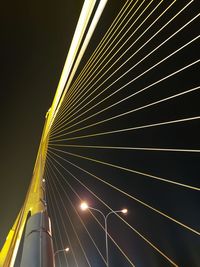 Low angle view of illuminated bridge against sky at night