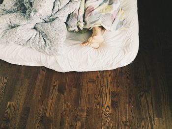 Low section of man sleeping on bed