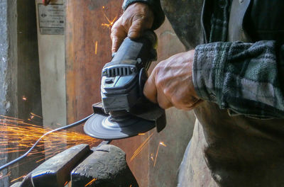 Midsection of blacksmith molding shape at workshop