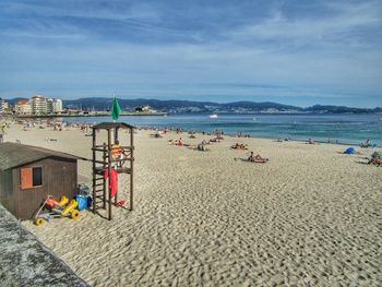 Deck chairs on beach against sky