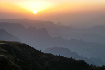 Scenic view of silhouette mountains against sky during sunset