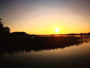 Scenic view of lake against sky during sunset