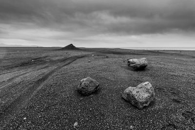 Scenic view of beach against cloudy sky