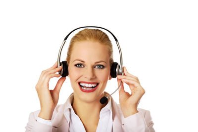 Portrait of smiling young woman using smart phone against white background