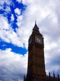 Low angle view of clock tower against cloudy sky