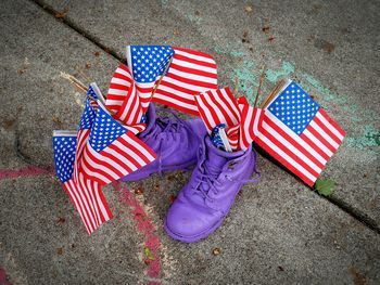 High angle view of american flags in purple shoes on footpath