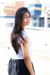 Portrait of a smiling young woman standing outdoors