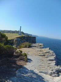 Scenic view of cliff against clear blue sky