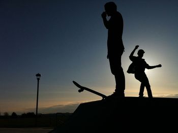 Low angle view of silhouette woman at sunset