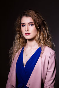 Portrait of a beautiful young woman over black background