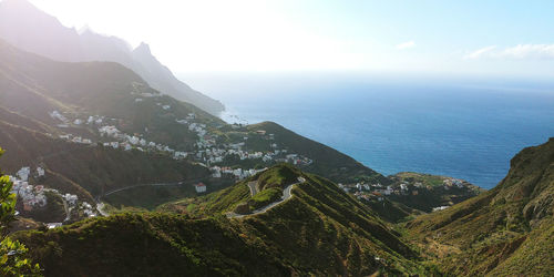 Scenic view of sea and mountains against sky