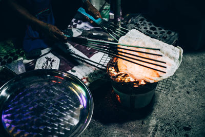 Close-up of man preparing food on barbecue grill