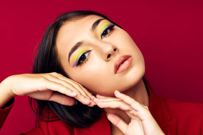 Portrait of young woman against yellow background