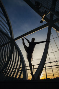 Low angle view of silhouette woman standing against sky