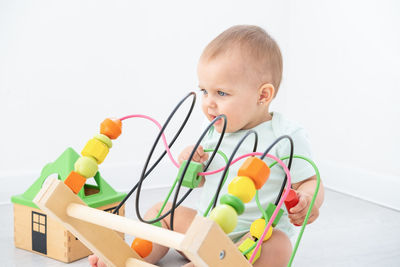 Portrait of cute boy playing with toy blocks against white background