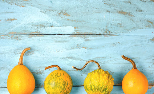 Close-up of orange fruits on table against wall