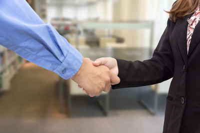 Cropped image of business people shaking hands in office