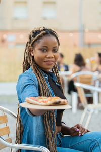 Portrait of young woman sitting outdoors