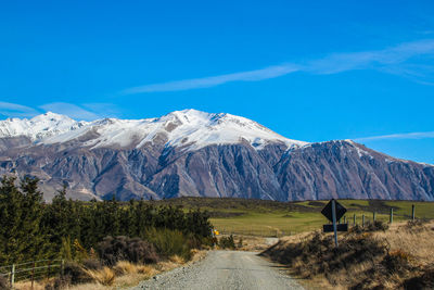 Scenic view of snowcapped mountains against blue sky