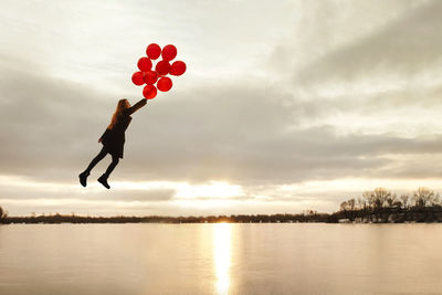 Full length of silhouette man with heart shape against sky during sunset